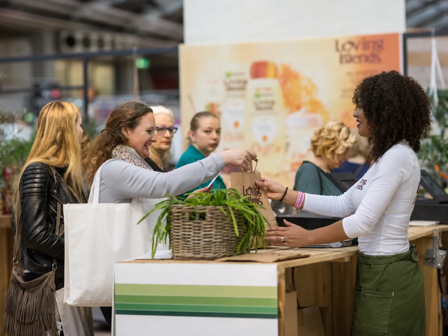 Garnier_beursstand_promotie Bezoeker doet een aankoop bij beursstand van Garnier tijdens een merkactivatie.