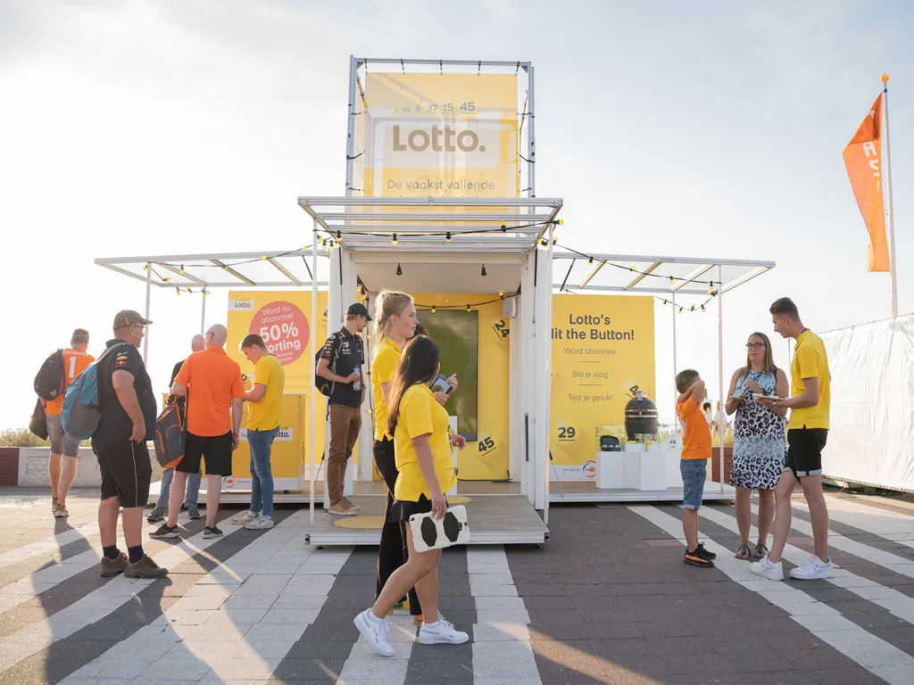 ezoekers nemen deel aan een Lotto-pop-upstore met interactieve merkactivatie mobiele pop-up op een evenement.