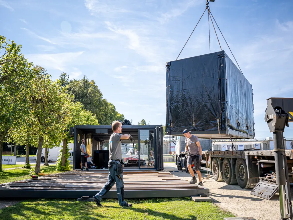 Opbouw van de Lotus Cars Roadshow in Parijs, waarbij modulaire units met een kraan worden geplaatst voor de tijdelijke merkactivatie.