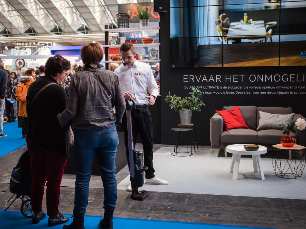 AEG_beursactivatie_1024x768 Bezoekers bekijken een demonstratie van een AEG-stofzuiger tijdens een interactieve merkactivatie op een consumentenbeurs.