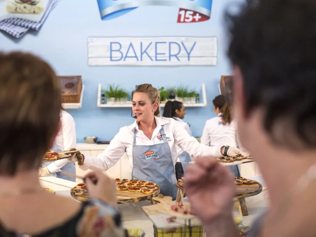 ERU_Balans_Bakery_proeverij_1024x768 Medewerker deelt hapjes uit aan bezoekers tijdens een ERU Balans Bakery-proeverij op een evenement.