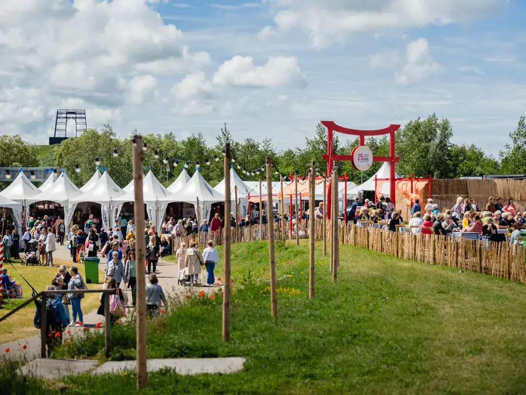 Festival_evenement_1024x768 Bezoekers wandelen langs tijdelijke paviljoens, pop-up stands en horecaterrassen tijdens een drukbezocht outdoor evenement.